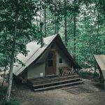 a wooden house with tarpaulin roof and chimney